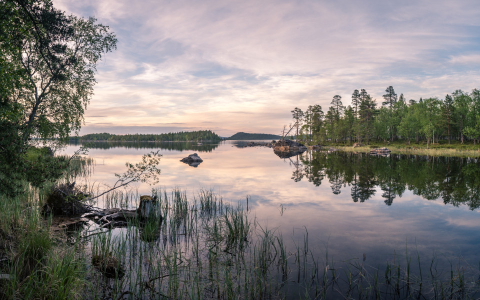 Panorama eines ruhigen Sees in Lappland zur Zeit der Mitternachtssonne. 